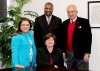 Dr. Darrell W. Cummings, standing center, will be honored by West Virginia Northern Community College at its annual fund-raising dinner March 14 at the college. Standing, from left, are Rana Spurlock, institutional advancement coordinator at the college; Cummings; and Nick Zervos, president of the board of the Wheeling campus Friends of the College. Seated is Dr. Vicki L. Riley, WVNCC president.