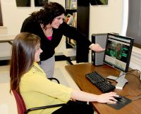 Stephanie Smith, academic program associate at West Virginia Northern Community College, standing, helps a student register for the institution’s award-winning Developmental Fast-Track program. The program has resulted in a significant reduction in the number of first-time students needing any developmental class at the college.